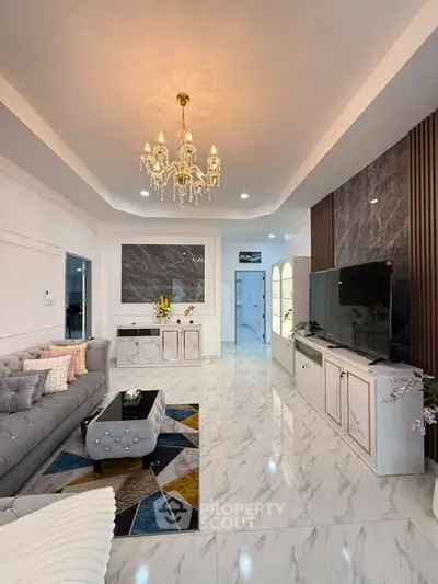 Luxurious living room with chandelier, marble flooring, and modern decor