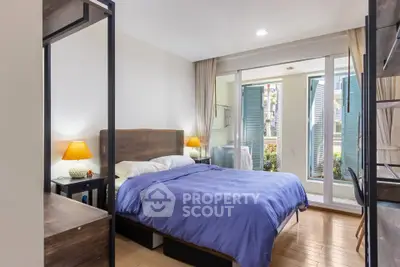 Spacious bedroom with modern decor and large windows offering natural light.