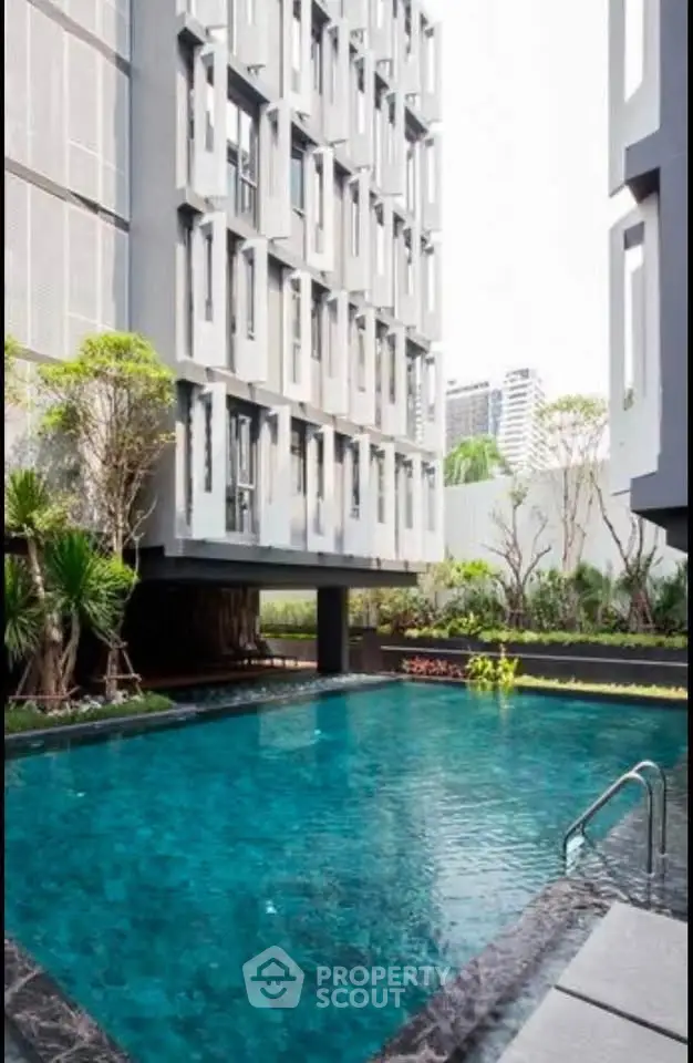 Modern apartment building with a luxurious outdoor pool and lush greenery, perfect for urban living.
