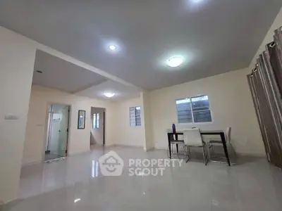 Spacious open-plan living area with modern dining setup and ample natural light.