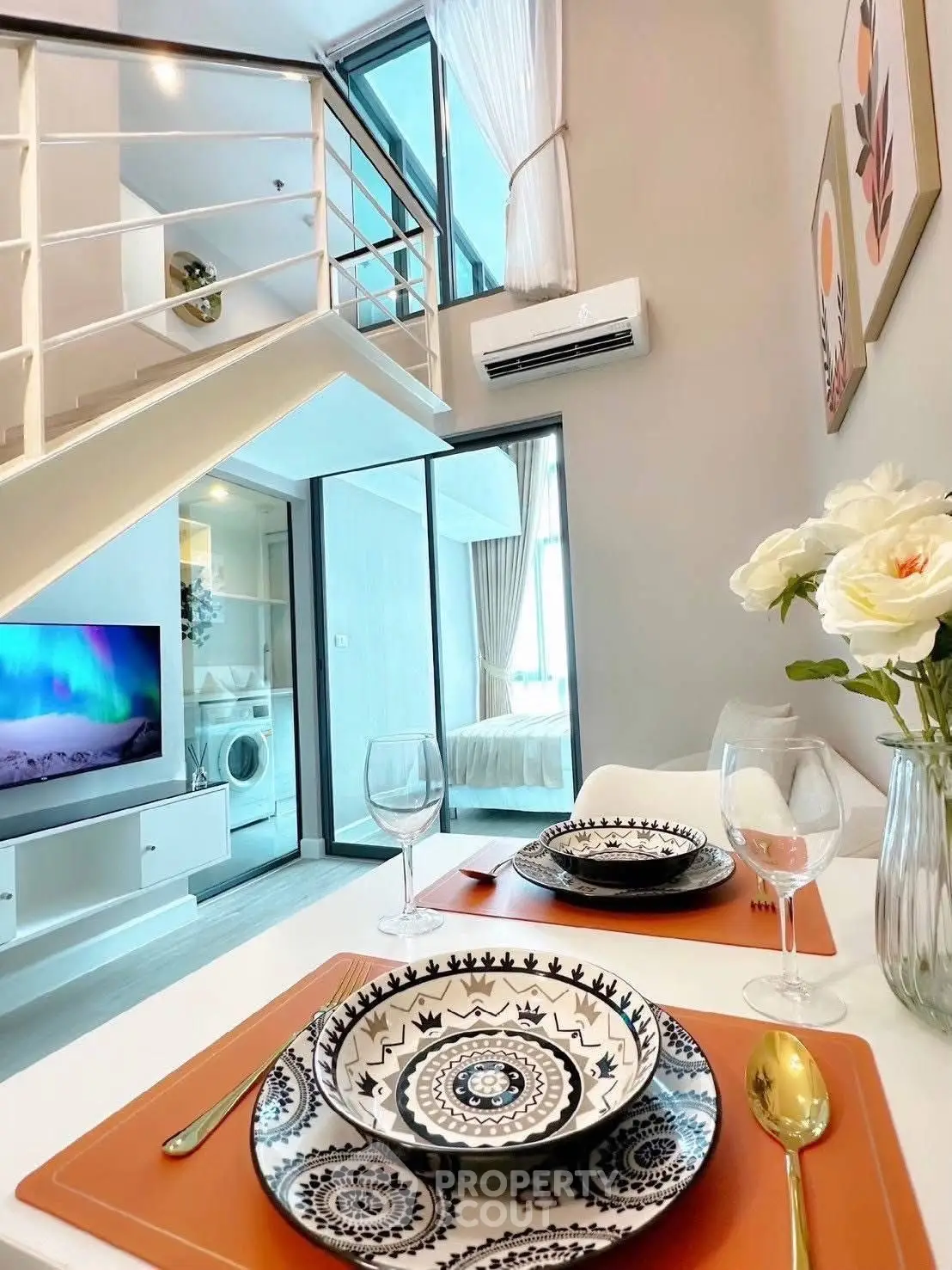 Modern duplex apartment with stylish dining area and cozy living space, featuring elegant decor and natural light.