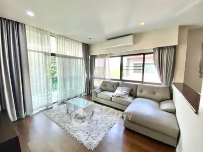 Spacious living room with modern sofa and large windows for natural light.