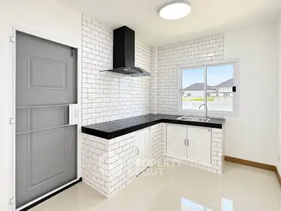 Modern kitchen with sleek black countertops and white subway tiles