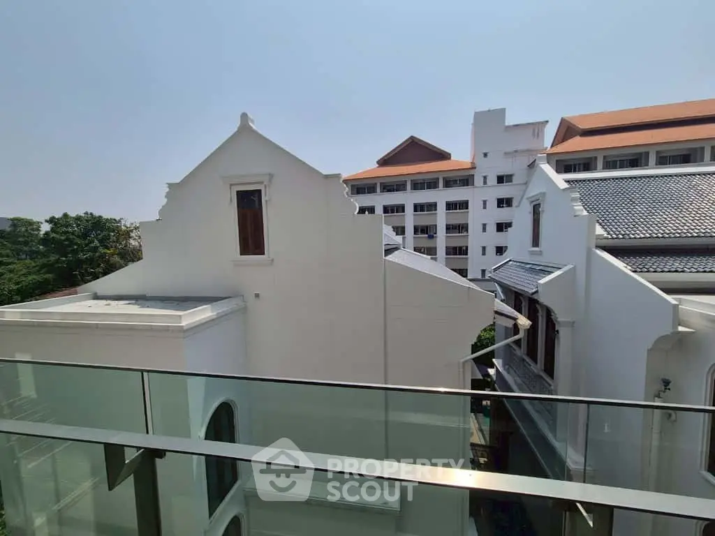 Charming view of traditional and modern architecture from a glass balcony.