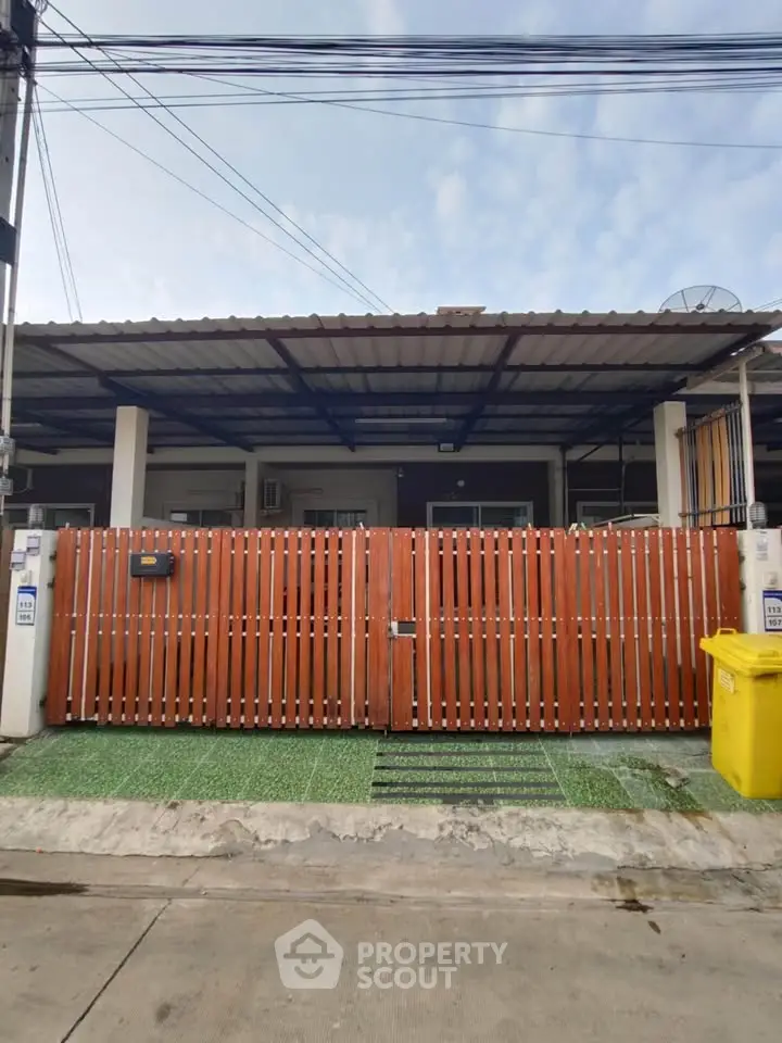 Charming single-story home with wooden fence and covered carport, perfect for cozy living.