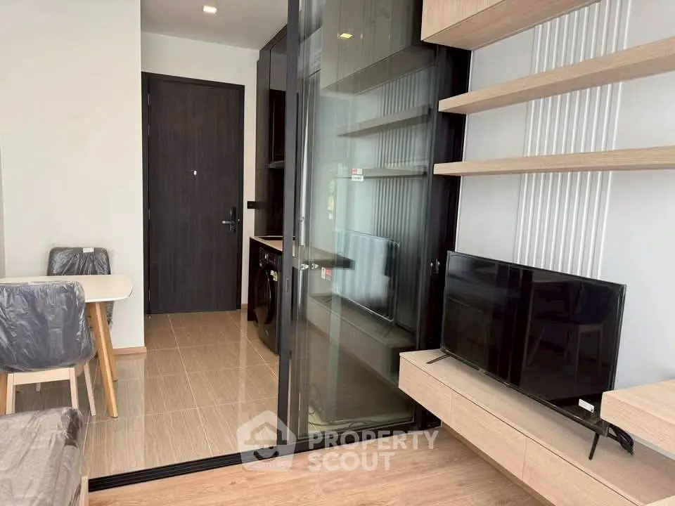 Modern living room with sleek furniture and glass partition in a stylish apartment.