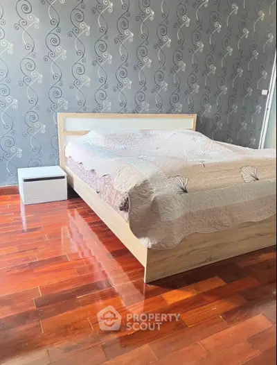 Stylish bedroom with elegant wallpaper and polished wooden flooring