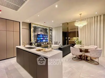 Luxurious open-plan living room with modern kitchen and elegant dining area, featuring a stunning chandelier.