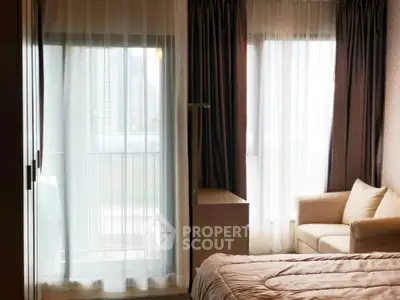 Cozy bedroom with large windows and a comfortable sofa, offering a serene ambiance and natural light.