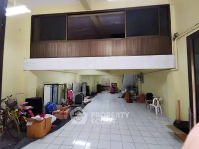 Spacious interior with mezzanine and tiled flooring, ideal for storage or renovation.