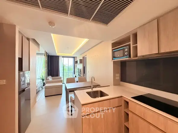 Modern open-layout kitchen and living room with sleek design and natural light.