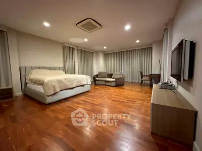 Spacious bedroom with modern furnishings and hardwood floors