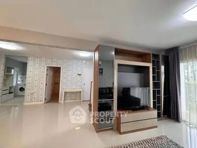 Modern living room with sleek furniture and open layout, featuring a TV unit and stylish decor.
