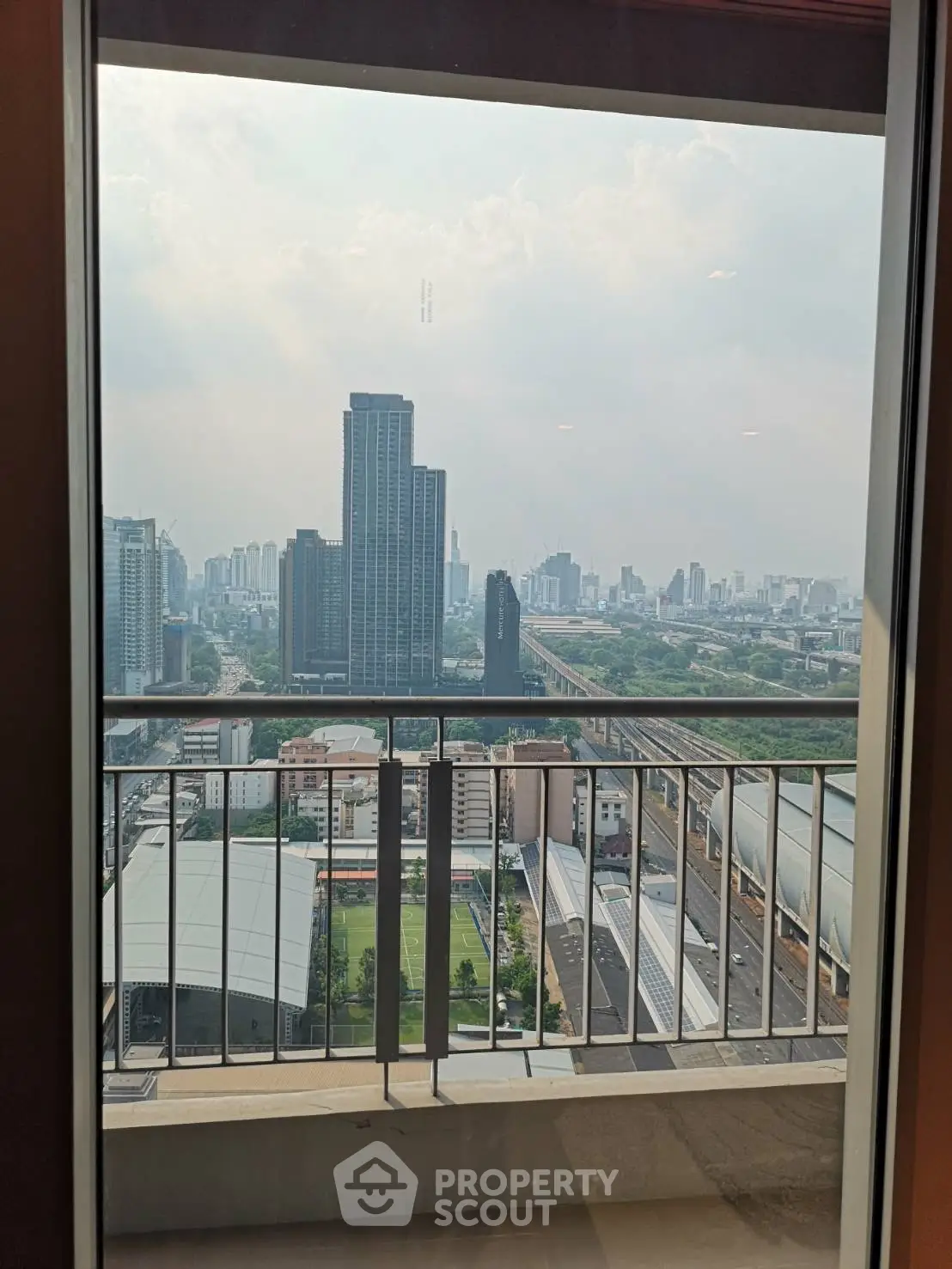 Stunning cityscape view from a high-rise balcony with modern railings, perfect for urban living.