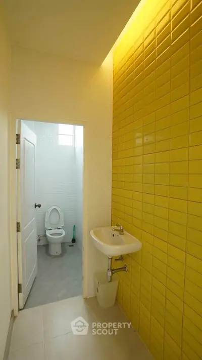 Modern bathroom with vibrant yellow tiles and minimalist design