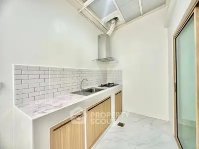 Modern minimalist kitchen with sleek white tiles and gas stove