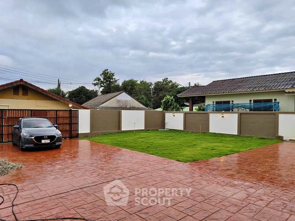 Spacious residential property with large driveway and lush green lawn, perfect for family living.