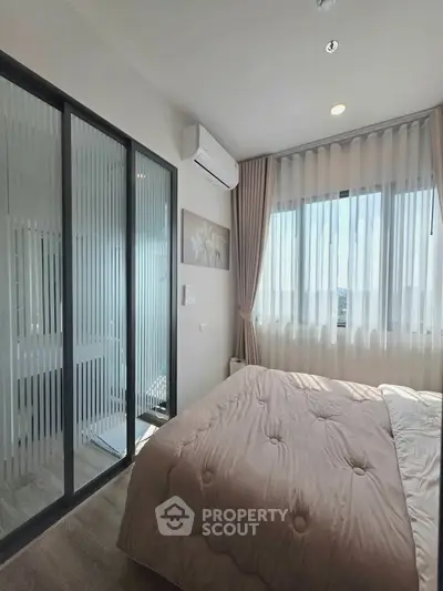 Modern bedroom with large window and air conditioning, featuring a cozy bed and elegant decor.