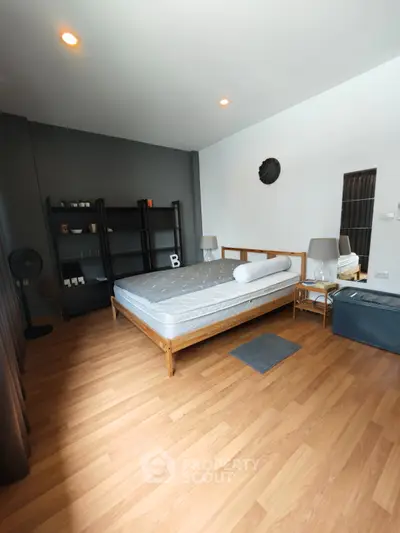 Spacious modern bedroom with wooden flooring and stylish decor