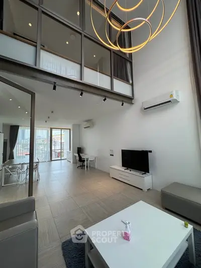 Spacious modern living room with high ceilings and stylish lighting in a luxury apartment.