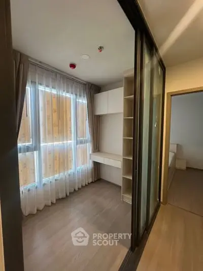 Modern study room with natural light and built-in desk in a cozy apartment.