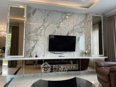 Luxurious living room with marble accent wall and modern TV setup.