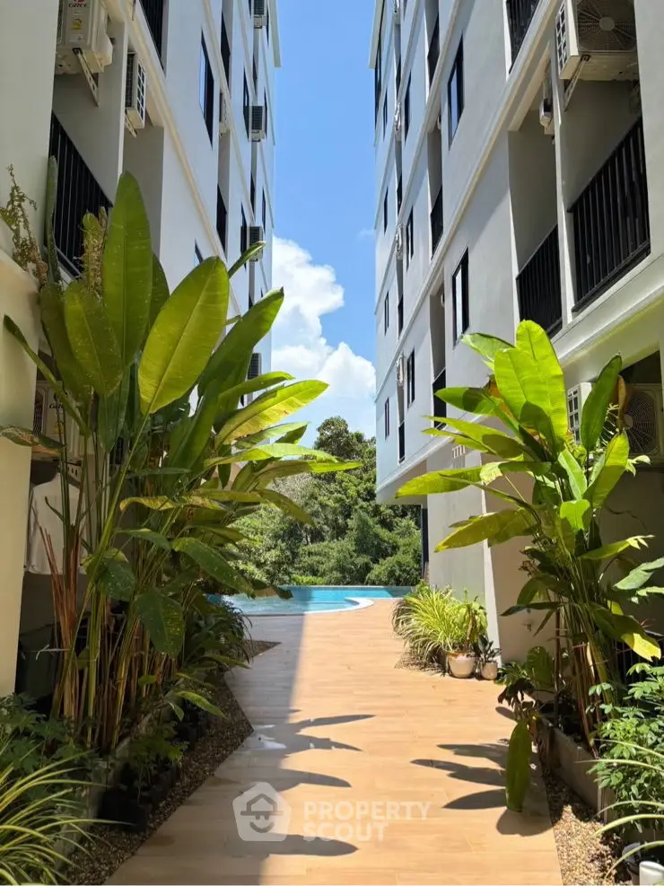 Stunning garden pathway leading to a serene pool surrounded by lush greenery.
