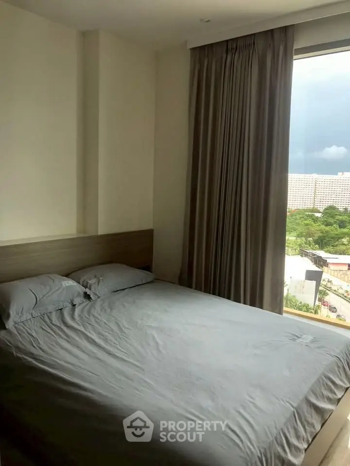 Cozy bedroom with large window offering a scenic view, perfect for relaxation and comfort.