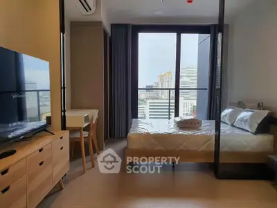 Modern bedroom with city view, featuring sleek furniture and large windows for natural light.