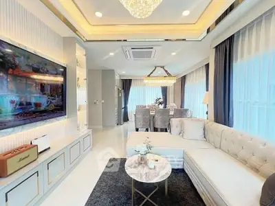Luxurious living room with elegant decor and spacious dining area, featuring a large TV and plush seating.