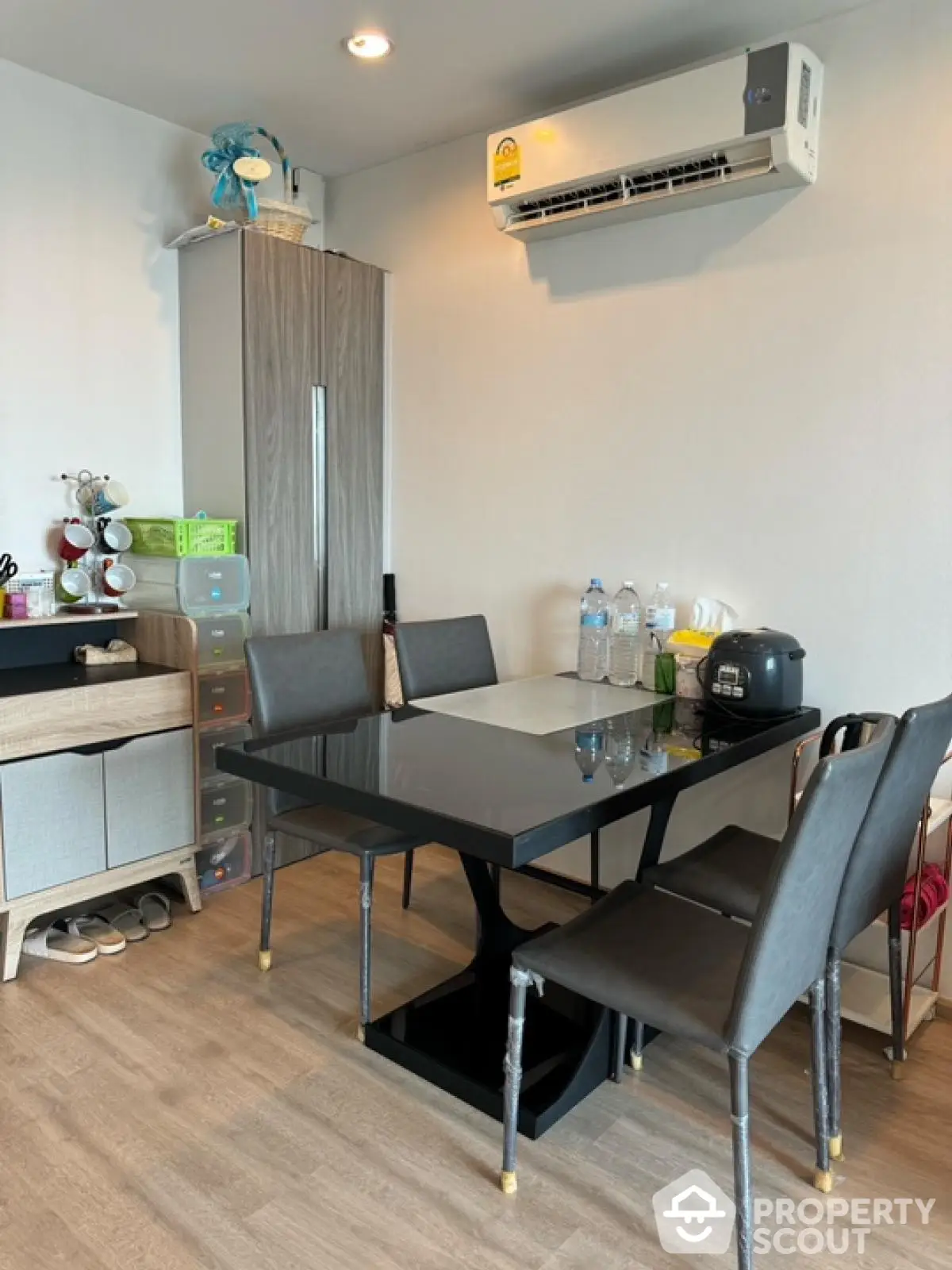 Modern dining area with sleek black table and chairs, featuring air conditioning and stylish decor.