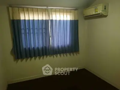 Cozy bedroom with air conditioning and blue curtains, perfect for a comfortable living space.