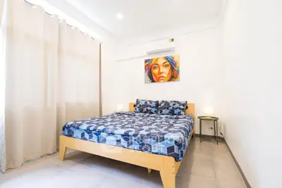 Bright and cozy bedroom with modern decor and air conditioning, perfect for relaxation.
