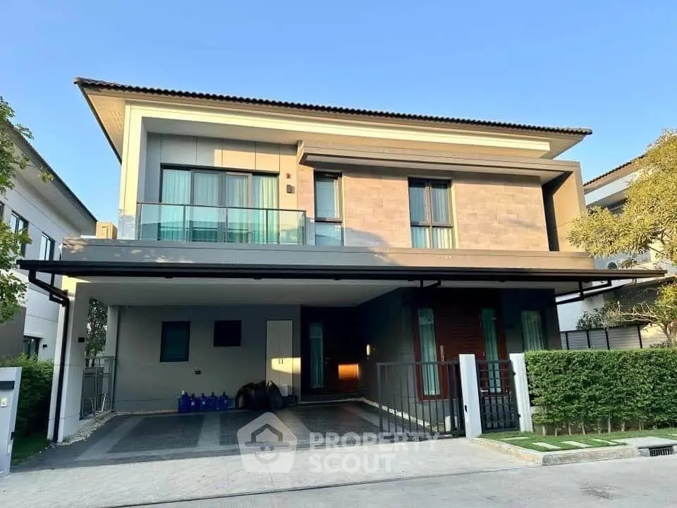 Modern two-story house with spacious driveway and sleek architectural design.