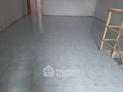 Spacious tiled room with railing, ideal for versatile use.