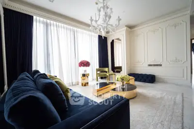 Luxurious living room with elegant decor, plush navy sofa, and chic chandelier, perfect for sophisticated living.