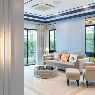 Elegant living room with modern decor and large windows offering garden views.