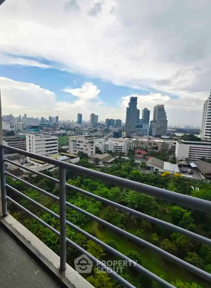 Stunning cityscape view from a high-rise balcony overlooking lush greenery and modern skyline.