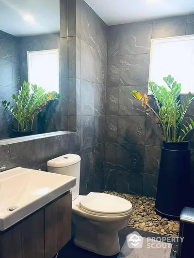 Modern bathroom with elegant stone tiles and lush green plants