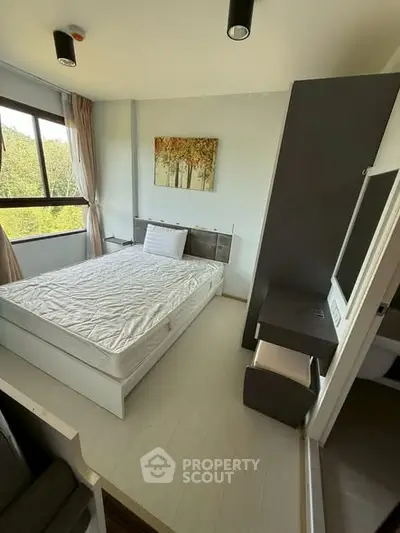 Cozy bedroom with large window and modern decor in a serene setting.