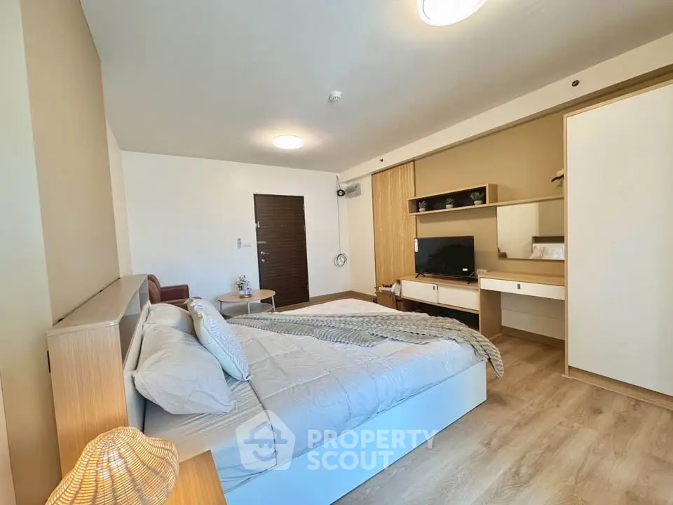 Spacious modern bedroom with stylish decor and ample natural light
