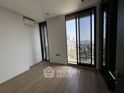 Spacious room with large windows offering stunning city views, perfect for a modern urban lifestyle.