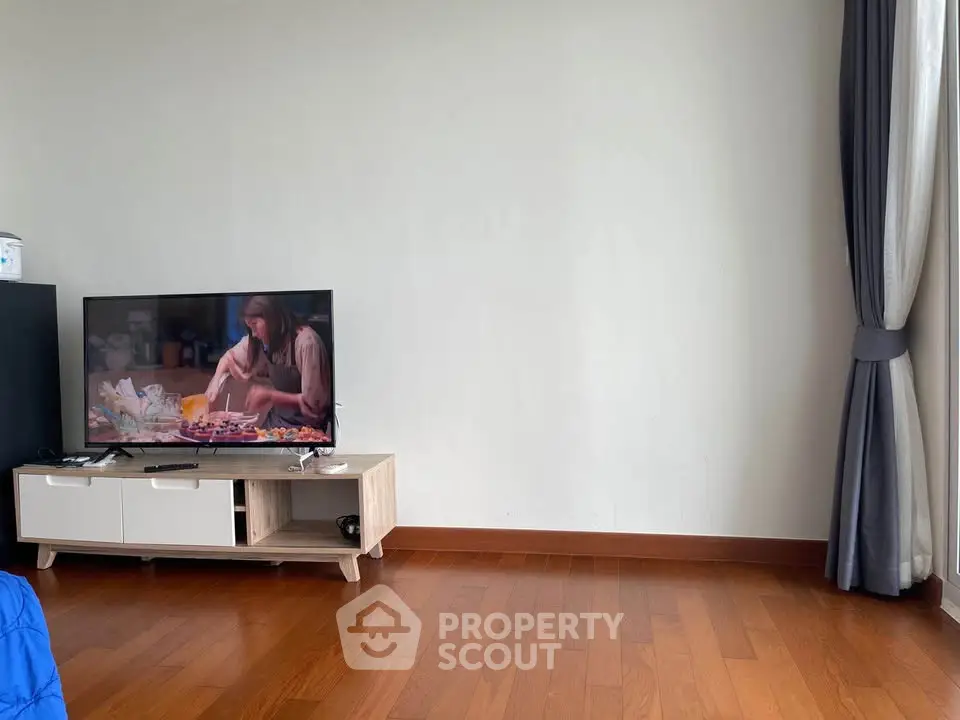 Spacious living room with wooden flooring and modern TV setup