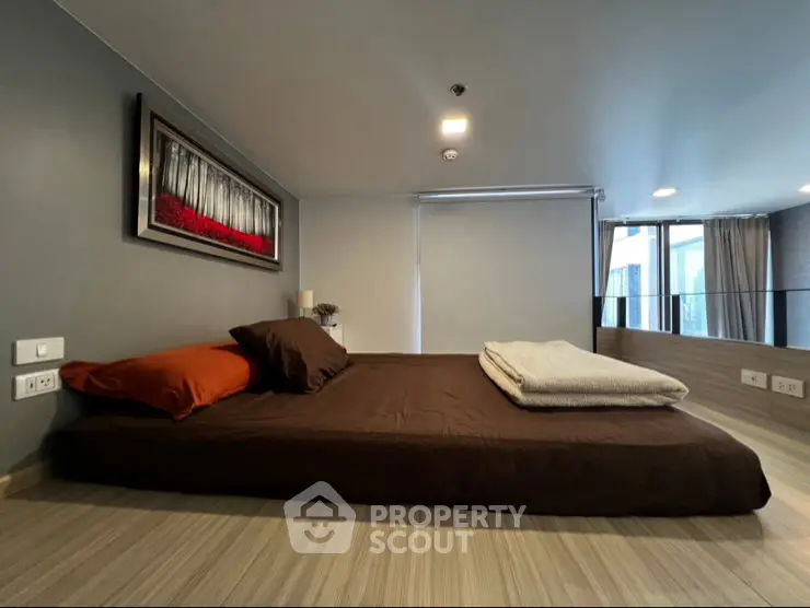 Modern bedroom with stylish decor and large windows offering natural light.