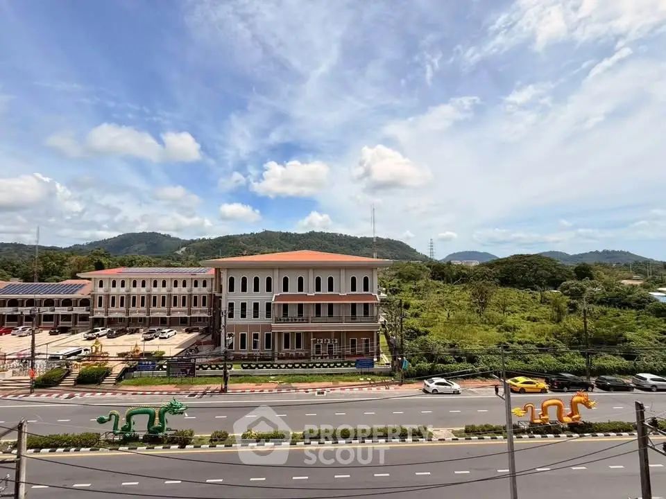 Scenic view of commercial building with lush green surroundings and mountain backdrop