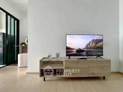 Modern living room with sleek TV stand and wall-mounted flat-screen TV, showcasing minimalist decor.