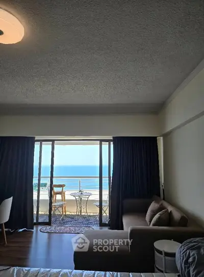 Spacious living room with ocean view and balcony access
