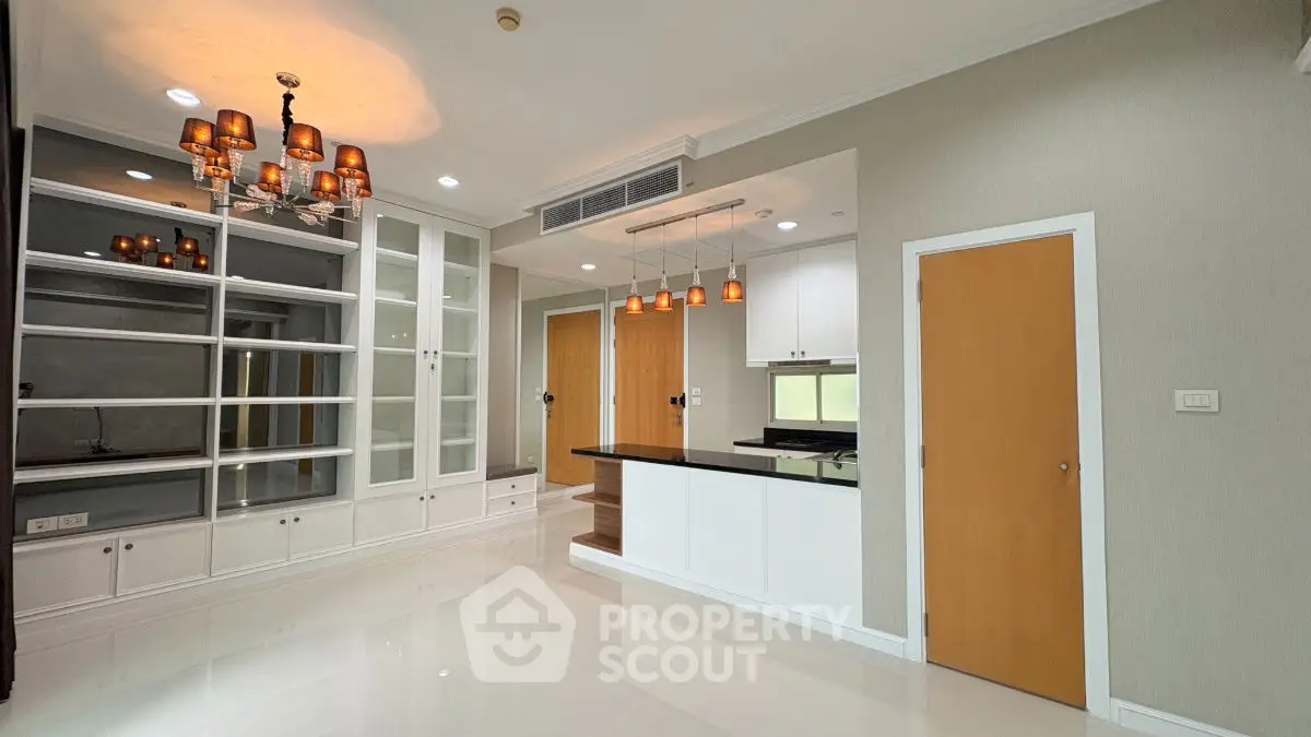 Spacious modern living room with elegant lighting and open kitchen layout.