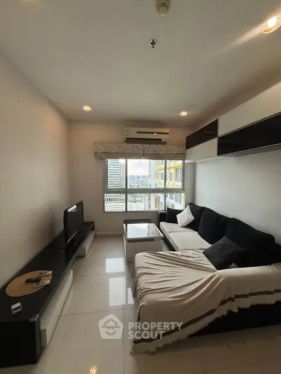 Modern living room with sleek furniture and large window offering city view