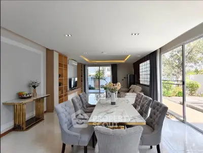 Luxurious open-plan living and dining area with elegant decor and garden view.